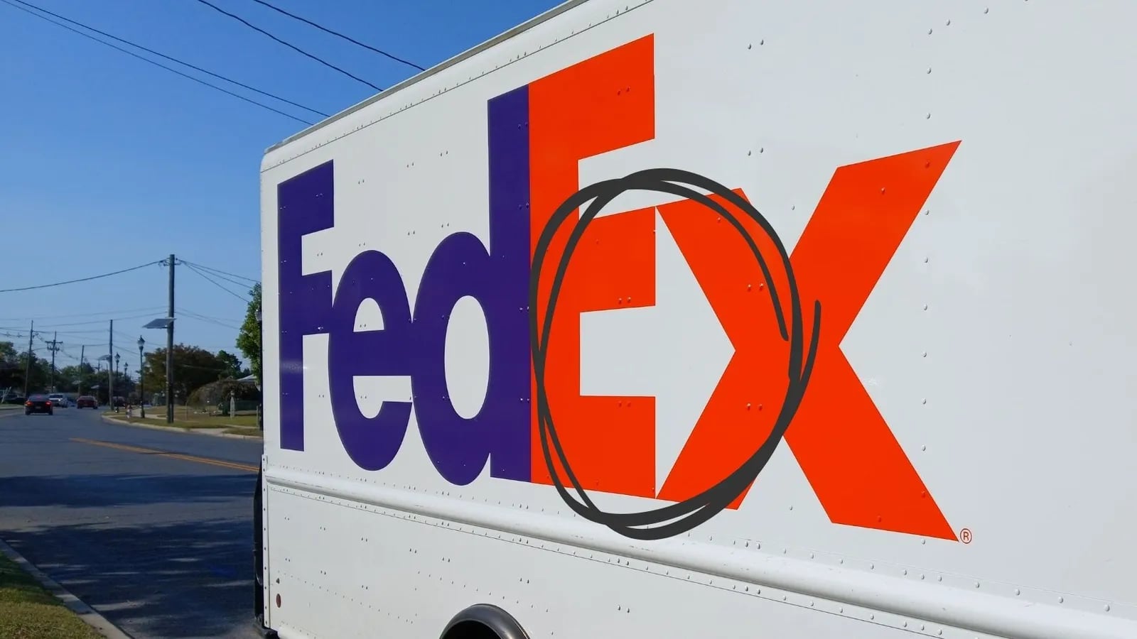 The FedEx logo on the side of a delivery truck, with the hidden arrow circled.