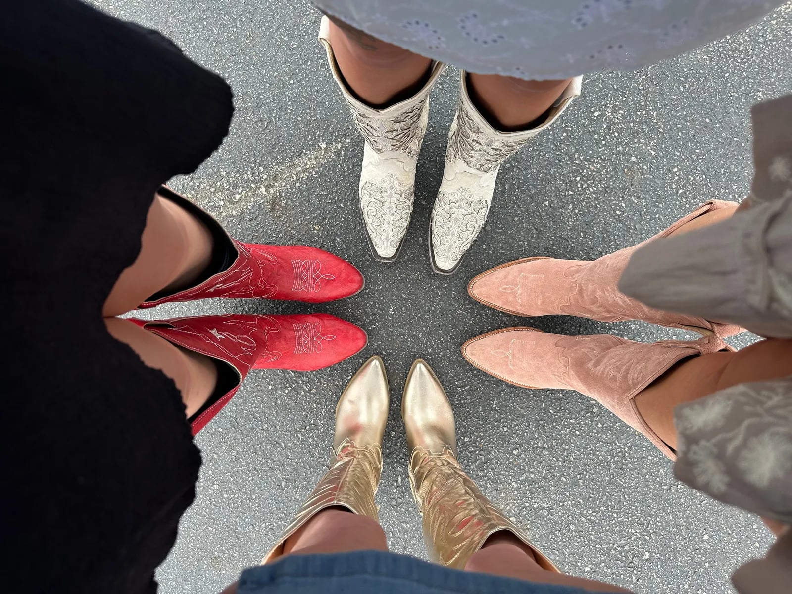 Several pairs of cowboy boots in a circle, seen from above.