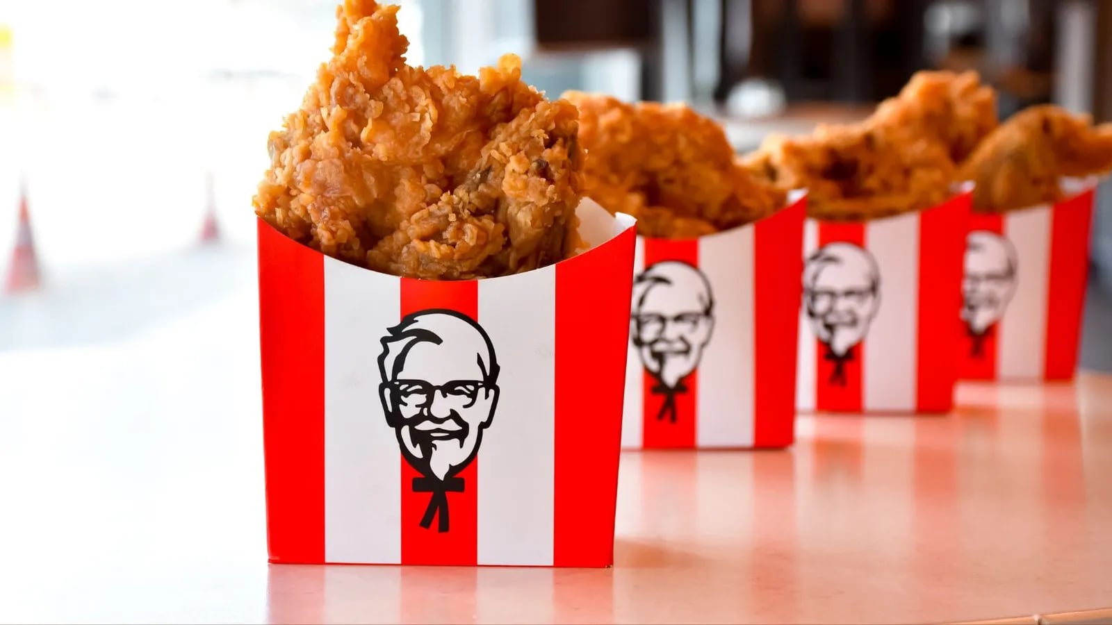 KFC buckets of fried chicken lined up on a counter.