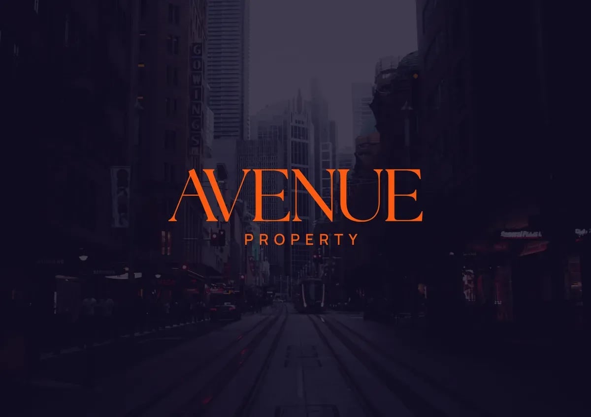The Avenue Property wordmark in orange on a dark city street.